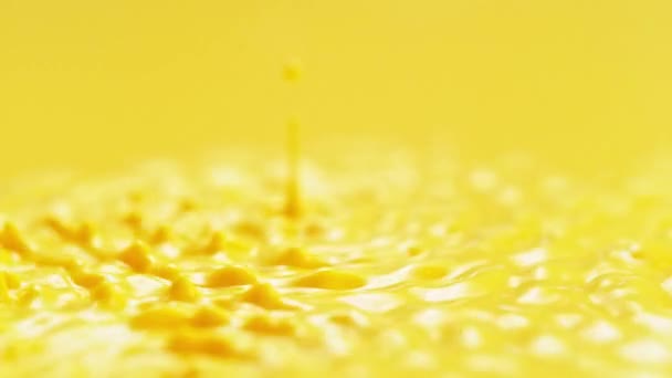 スローモーションによる黄色の塗装スプラッシング アブストラクトエネルギー的に一定のバウンス流体は液滴とスプラッシュを作ります — ストック動画