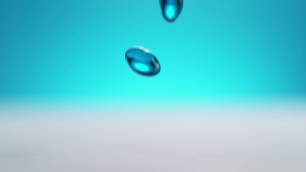 Blue Softgel Capsules Falling White Clean Table Bouncing Blue Background — Stock Video
