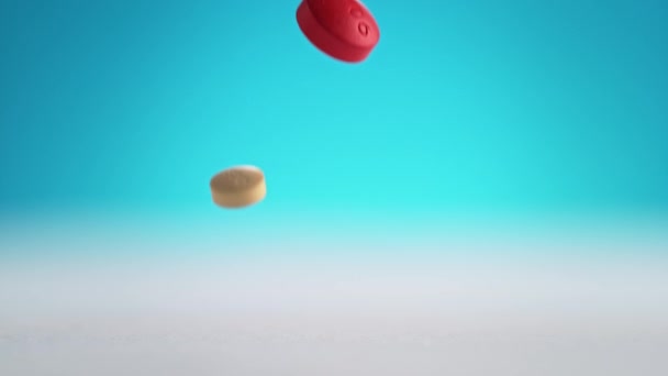 Красочные Таблетки Таблетки Падать Белый Чистый Стол Выпрыгивая Синий Фон — стоковое видео