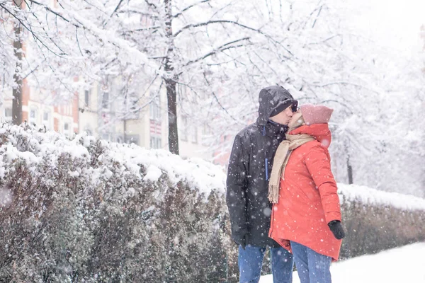 Mutlu çift, kış parkında birbirlerine sarılıp öpüşüyorlar..