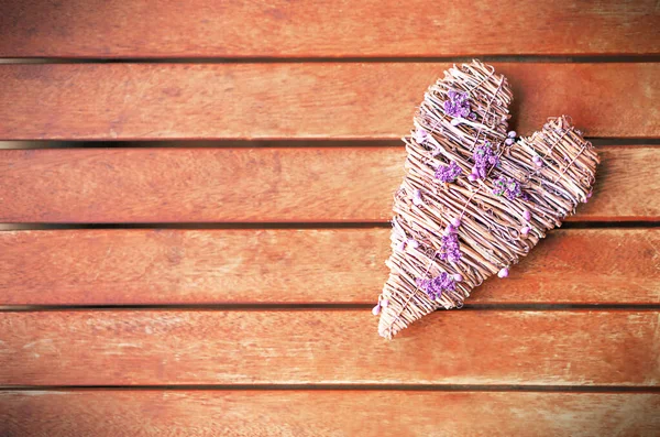 Bright purple heart on the right site on the brown vintage wooden background. Copy space.