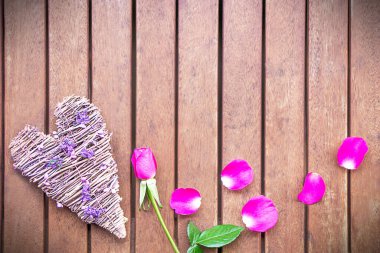 Wood heart and fresh pink rose with petals. Valentines day concept. Copy space. High quality photo.