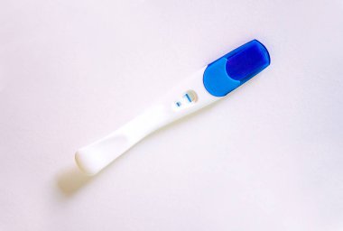 Positive pregnancy test with two stripes on white table. High quality photo clipart