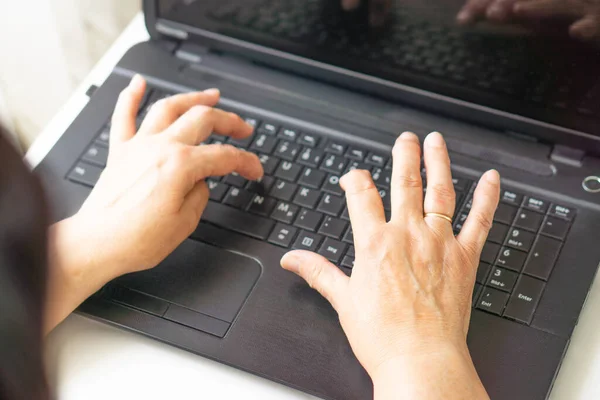 Klavye dizüstü bilgisayarında yazan kadın elleri. İş, eğitim, programlama, teknoloji ve insan kavramı. Dizüstü bilgisayar klavyesinde yazı yazan yaşlı kadının ellerini kapat.. 