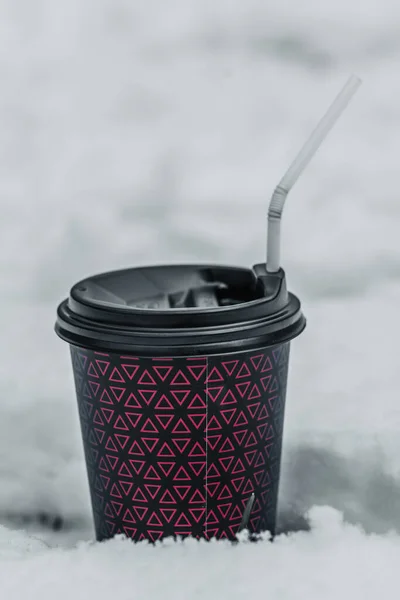 coffee cup with a straw on the snow. High quality photo