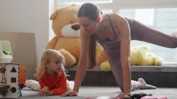 Mother Does Sport Exercises While Daughter Plays Nursury Room Pretty — Stockvideo