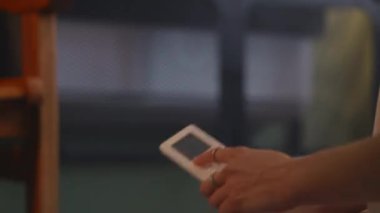Kadın eli klimayı uzaktan açıyor, metal örgülerle gizleniyor, sıcaklık 20 dereceye ayarlı. Yüksek verimli ısıtma çözeltisi enerji ve para tasarrufu sağlıyor, alternatif ve güvenli ısıtma. Karargah 4K