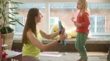 Anne kızına spor egzersizlerini, bebek odasında aile fitness 'ini, oyuncakların dağınıklığını, güzel sarışın çocuğu, parlak kıyafetler giyen kadınları gösterir. Spor için zaman bulmaya çalışır.