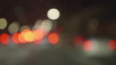 Arabanın ön camından gece görüş açısı, sokak lambaları, hareket eden odak noktası, bokeh etkisi. Yüksek kalite 4k görüntü