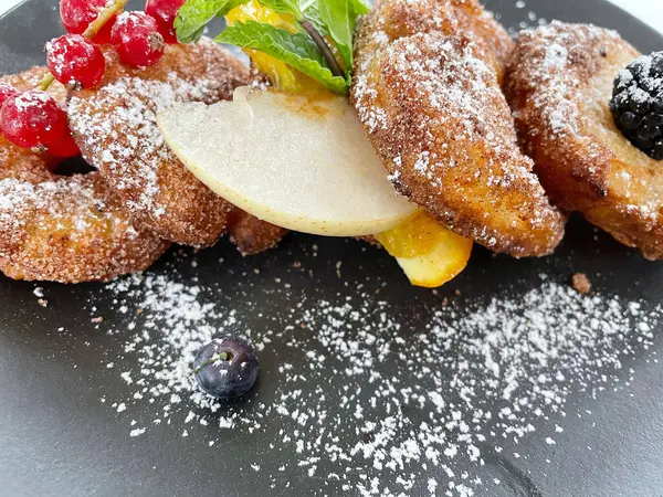 Elmalı börek, siyah bir tabakta, şeker ve meyveli. .