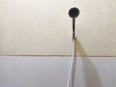 Siyah beyaz duş başlığı fayanslı banyo duvarında asılı