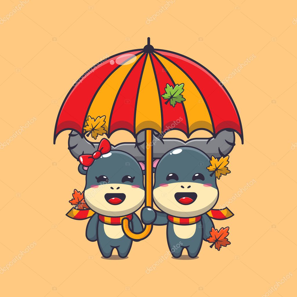 Cute couple buffalo with umbrella at autumn season. Mascot cartoon vector illustration suitable for poster, brochure, web, mascot, sticker, logo and icon.