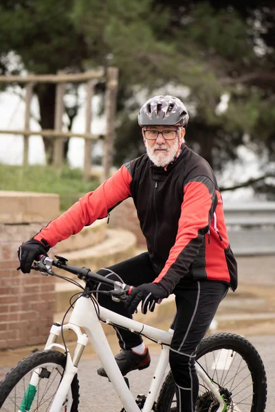 older man riding a mountain bike, equipped and healthy
