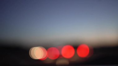 Bir arabanın içinden hareket halindeki otoyolun yatay videosu, odak dışı ışıklar ve işaretler, gün batımında hareket algılanır.