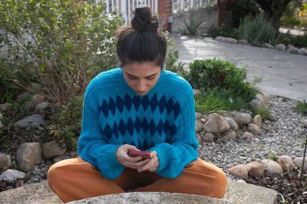 Meisje Zit Aan Een Stenen Tuintafel Kijkend Naar Haar Mobiele — Stockfoto