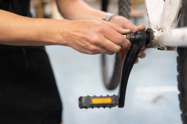 Bir kadının ellerinin bisiklet pedalının tamiri, bisiklet atölyesi, ulaşım araçlarının kişisel bakımı....