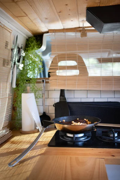 beautiful wooden camper kitchen with window light, in the paella hamburger and chickpeas, separation of bamboo curtain to the front seats
