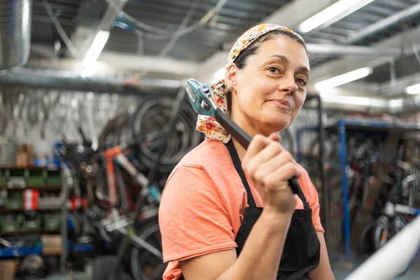 woman with tool in hand fixing bikes, image inspired by the can do it poster of working women. female bicycle mechanics
