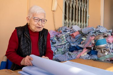 Çizgili kumaşlı kadın, geleneksel çizgili ve ekose büyükannenin elbisesini dikmek için önlük, kumaş dağ elbisesi..