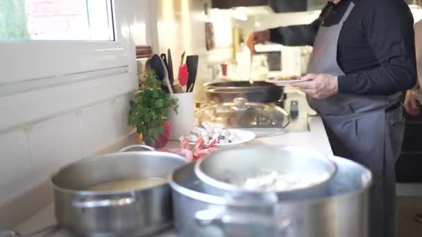 해산물 요리가 부엌의 앞치마와 앞치마를 두르고 요리를 알아볼 수없는 파벨라의 — 비디오