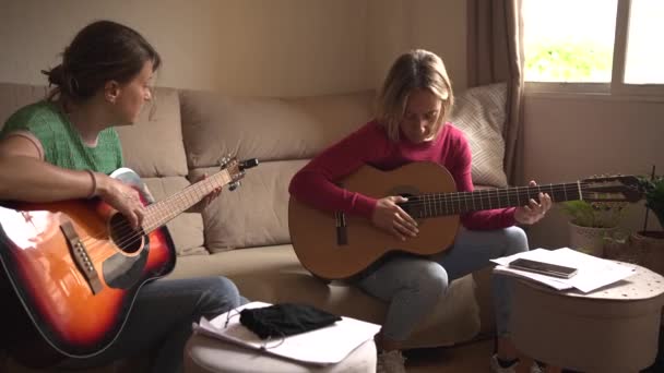 Dos Mujeres Unos Cuarenta Años Practicando Guitarra Sofá Afinando Sus — Vídeo de stock