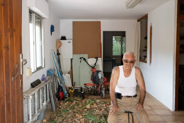 Starszy Mężczyzna Siedzący Stołku Pozujący Zbiorami Cebuli Garażu Osoba Osiemdziesiątce — Zdjęcie stockowe