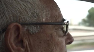 Reçeteli güneş gözlüklü, koyu tenli ve gri saçlı 80 yaşındaki bir adamın göz ayrıntıları..
