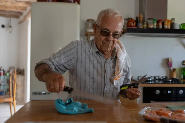 Osiemdziesięcioletni Mężczyzna Kuchni Szmatą Ramieniu Nożem Chleba Czyszczący Drewno Drewnianą — Zdjęcie stockowe