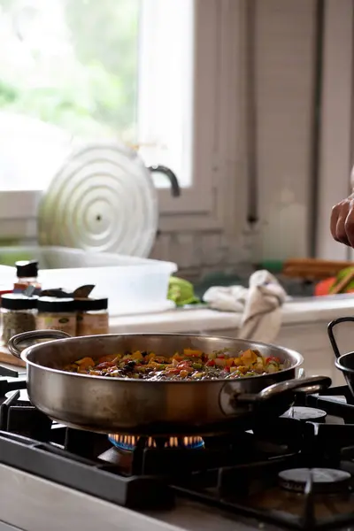 油炸洋葱 胡椒粉和西红柿在前景中 厨房里有窗户和自然光 图库照片