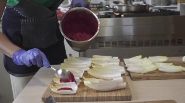 Ot ve kaşıkla doldurulmuş hindiba yapraklı pancar humuslu kadın.