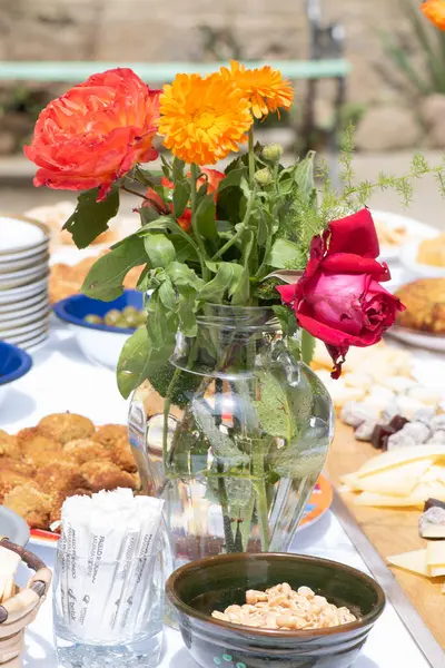在餐桌中央摆满了天然玫瑰的花束 用自助餐的形式招待客人 作为庆祝 免版税图库照片