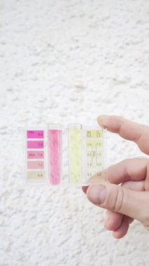 Elin yüzme havuzunun duvarında pH ve klor kontrol cihazı tuttuğunu gösteren bir video. 