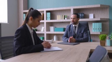 Takım elbiseli bir adam, ofiste patron masaya oturur, genç bir kadınla konuşur, iş meselelerini tartışırlar, işçi üzülür, patron astının işinden memnun olmaz.