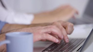 Modern dizüstü bilgisayarda çalışan genç bir işçi. Evinde yakın plan araştırma yapıyor..