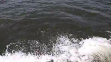 Dalgalar gölde şekillenir, kayık hızlandıkça.