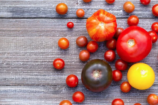 Różne Dojrzałe Kolorowe Pomidory Szarym Drewnianym Stole Ogrodowym Widok Góry — Zdjęcie stockowe