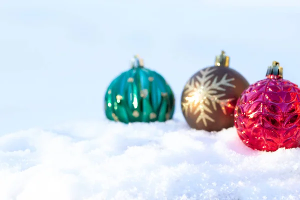 Три Красный Коричневый Зеленый Яркие Новогодние Лампочки Блестящими Орнаментами Снегу — стоковое фото