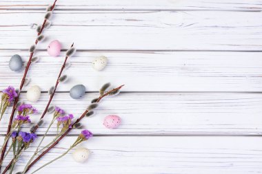 Düz Paskalya kompozisyonu söğüt dalları, kuru çiçekler (gypìila ve statice), beyaz ahşap arka planda tüyler ve yumurtalar ile yatıyordu.