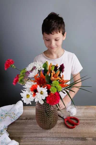 Милый Веселый Мальчик Раскладывает Цветы Букет Вазе Деревянным Столом Дома Стоковая Картинка