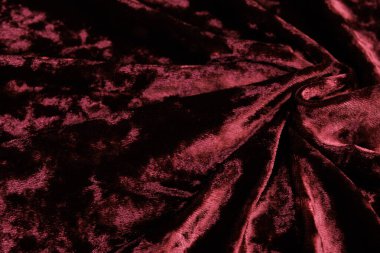 Lüks, koyu kırmızı kadife kumaş. Arka plan olarak kullanılıyor. Yumuşak ve pürüzsüz katlı tekstil..