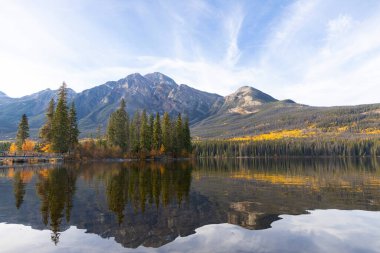 Dağ gölü manzaralı, sarı ve yeşil ağaçlar ve Rocky dağlarındaki mavi sakin sular. Piramit Gölü, Jasper Ulusal Parkı, Alberta, Kanada