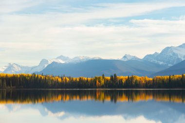 Dağ gölü manzaralı, sarı ve yeşil ağaçlar ve Rocky dağlarındaki mavi sakin sular. Piramit Gölü, Jasper Ulusal Parkı, Alberta, Kanada