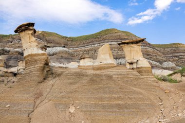 Meşhur kabadayılar, çorak topraklarda üzerinde kapak taşı olan kumtaşı sütunlar. Serseriler, Drumheller, Alberta, Kanada.