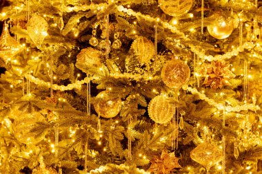 Kristallerden, cam süslemelerden, parlak ışıklarla aydınlatılmış boncuklu asma çiçeklerden oluşan yaratıcı süslemeleri olan şenlikli Noel ağacı..
