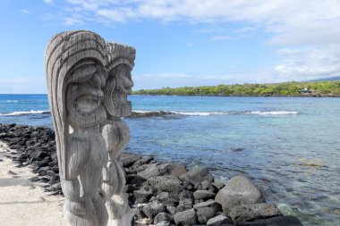 Wooden carved statues of Hawaiian gods, Protectors ki'i, at the shore of Pacific ocean. Pu?uhonua o Honaunau national historical park, Hawaii, the USA. clipart