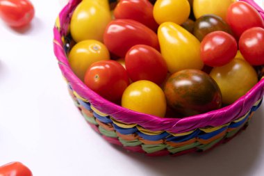 Beyaz arkaplanda parlak ve renkli domatesler (sarı armut şekilli, kırmızı ve siyah çizgili). Taze organik bahçe ürünleri.