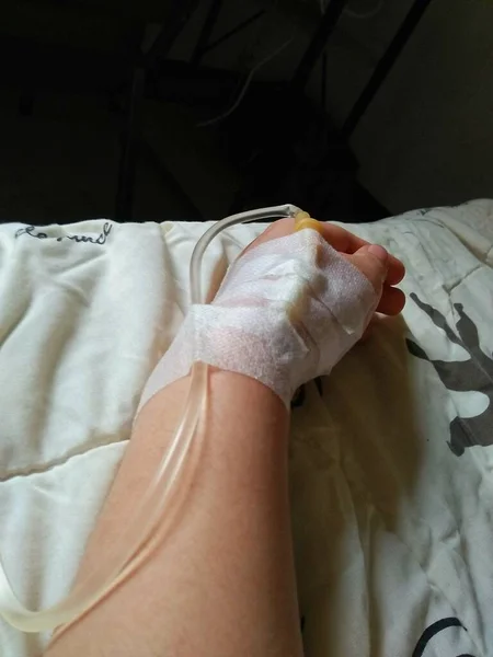 Patient with saline intravenous (IV) on her hand.