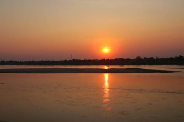 Akşama Mekong nehrinin kıyısında gün batımında..