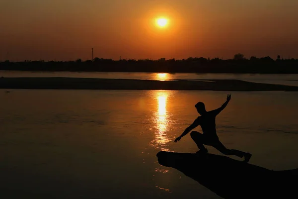 Silhouette Eines Mannes Beim Yoga Ufer Des Flusses Bei Sonnenuntergang — Stockfoto