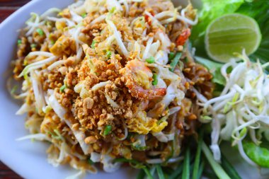 Pad Thai ya da Tayland usulü kızarmış erişteli beyaz tabakta karides ve sebze..